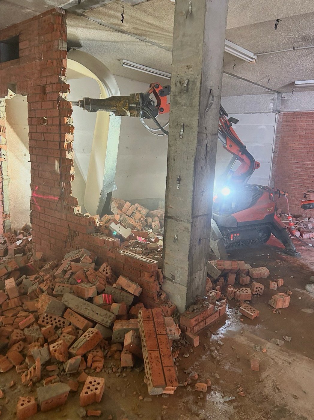 Remote demolition robot removing internal brick wall